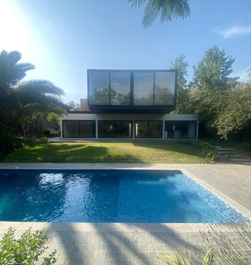 Casa LL, Huechuraba — fachada con volumen en vidrio y madera sobre piscina